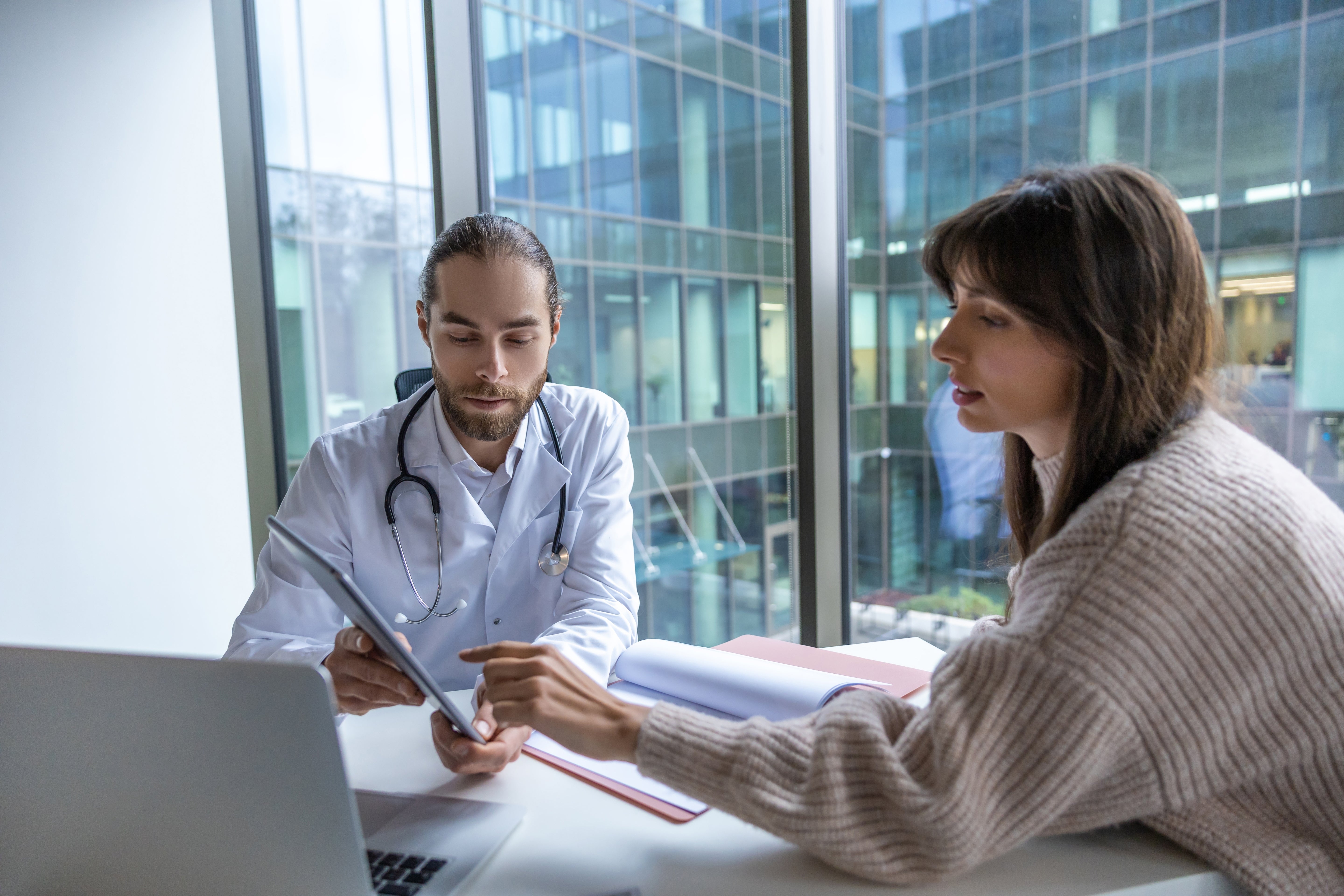 Male consultant discussing with female patient in a professional office setting