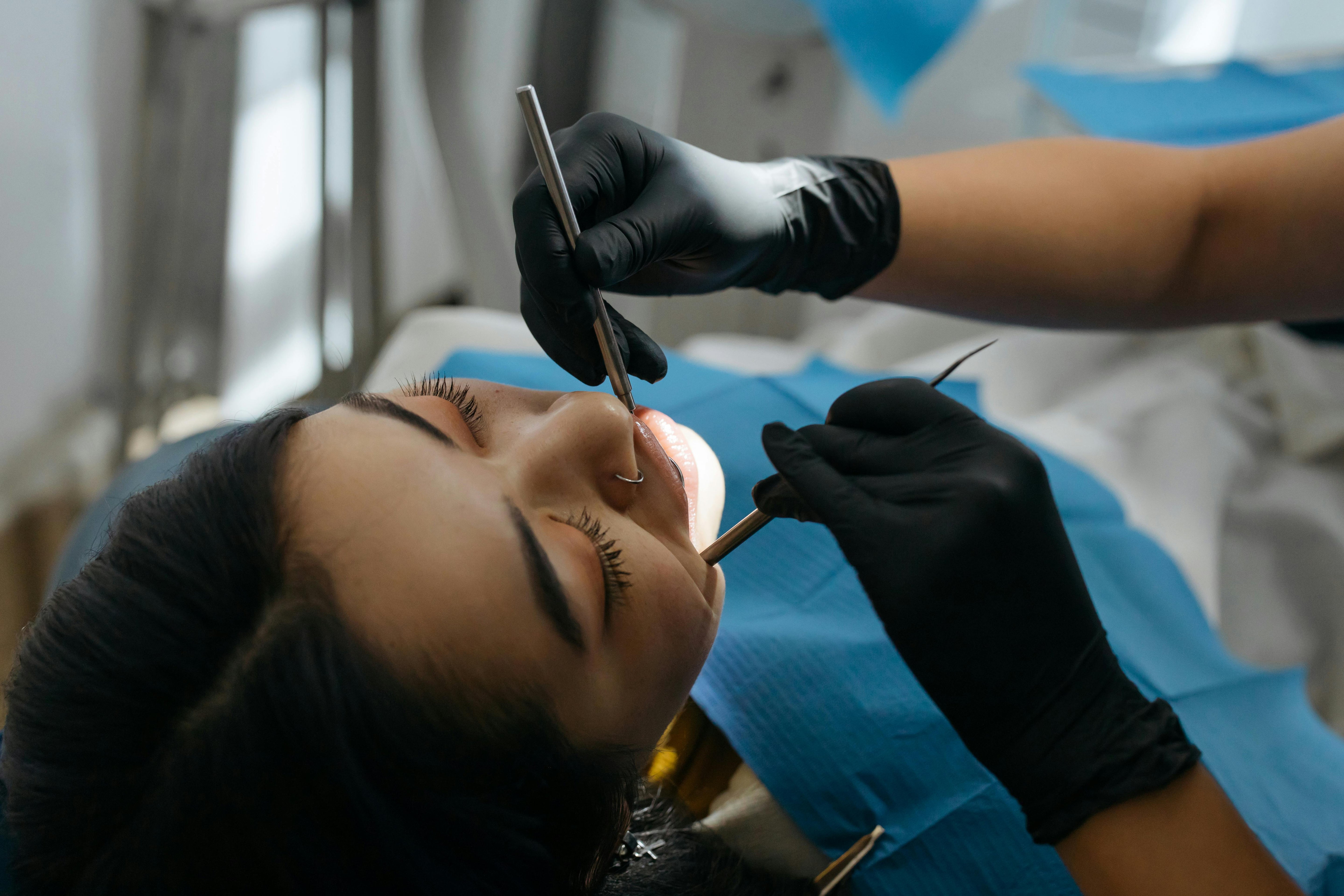 A women checking her oral health by the dentist with tools