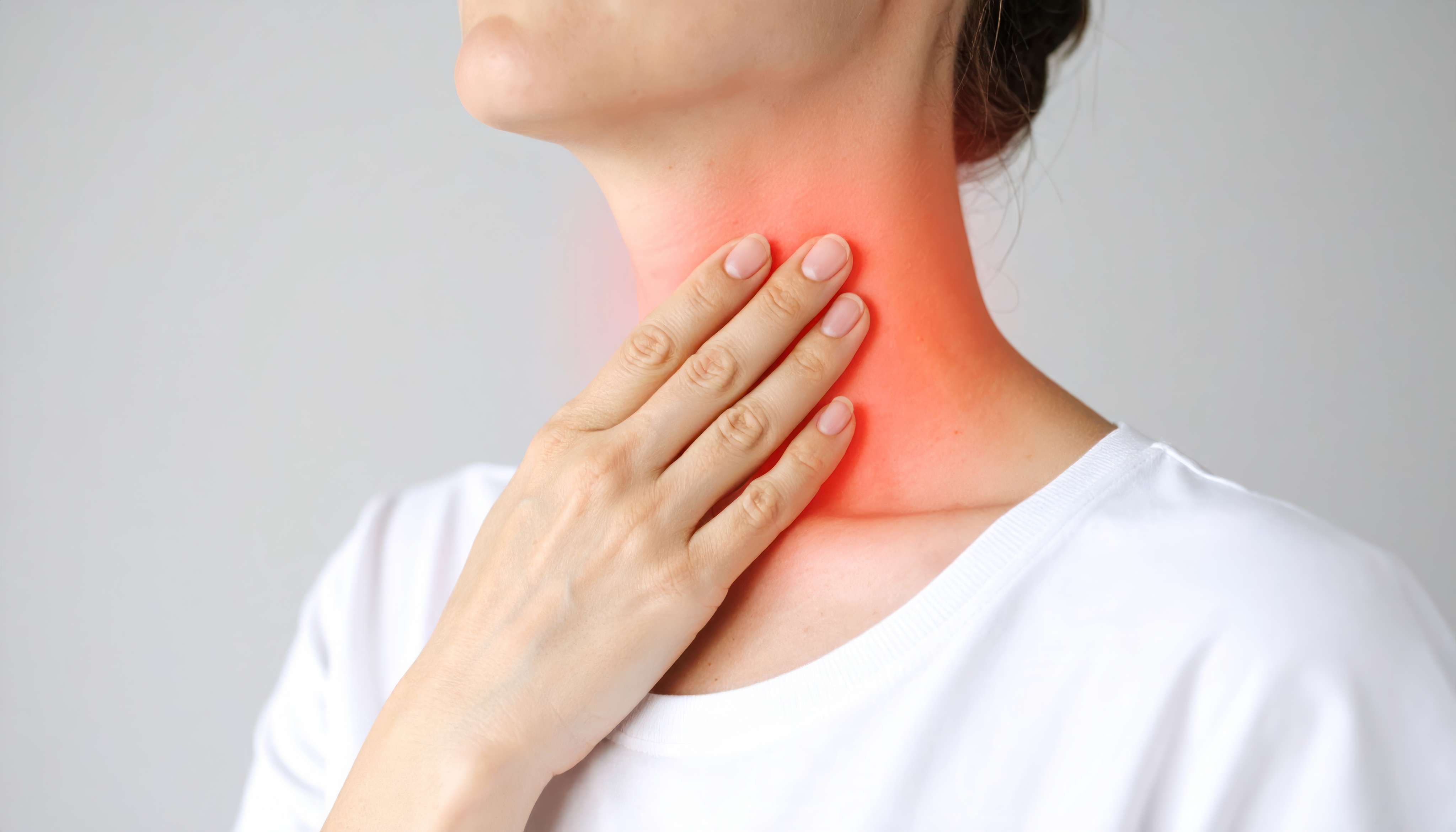 woman touching inflamed throat with hand representing sore throat 