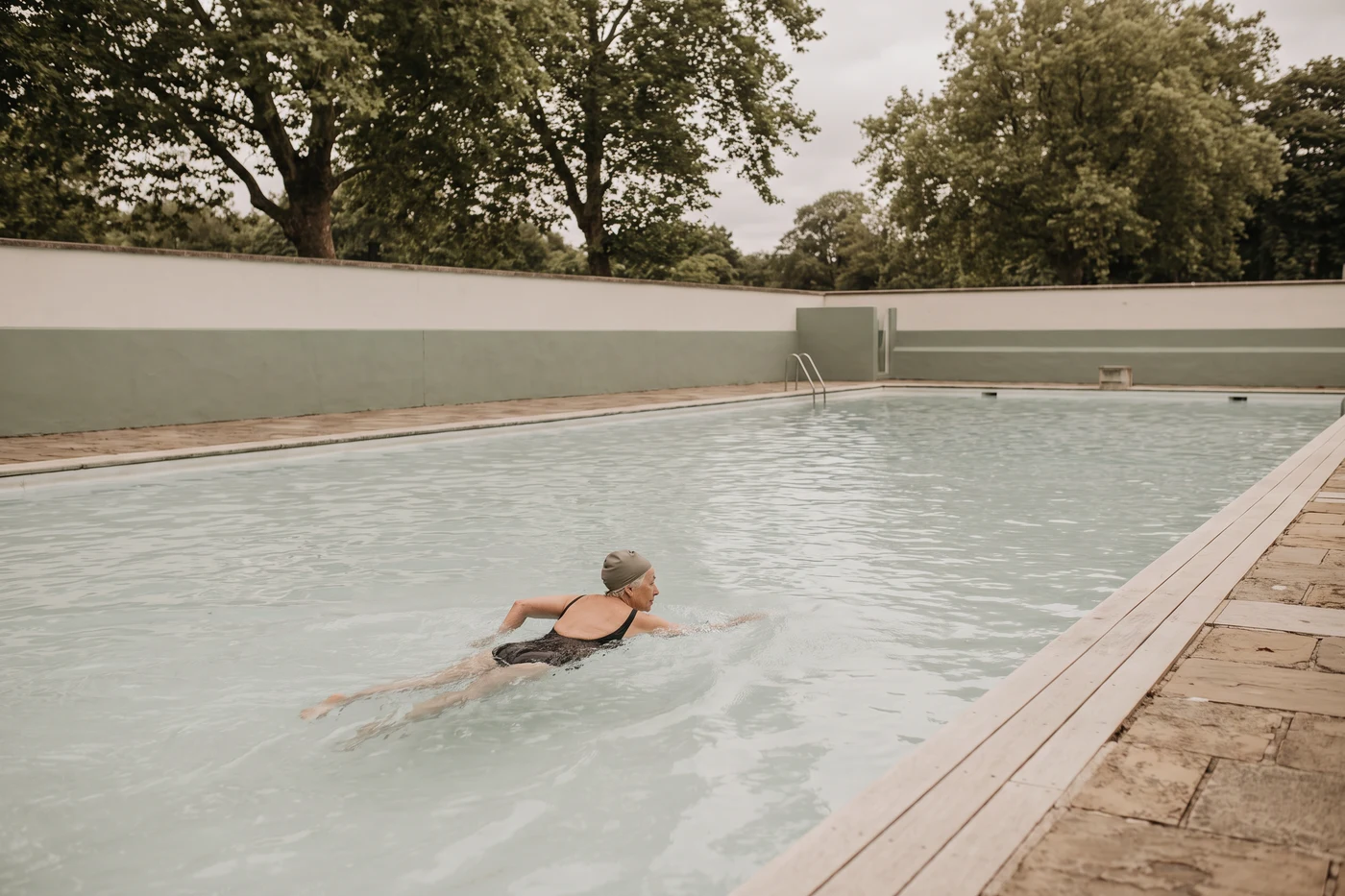 A woman swimming lengths in an open air pool
